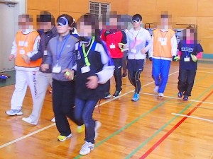 2月28日：伴走者育成研修会の画像。二人一組になり、一人がアイマスクをし、もう一人が伴走を行なう実技の様子。